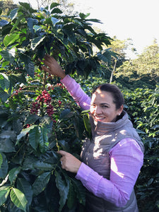 La señora caballero junto a sus n arbusto de café en su finca la quebrada en Honduras 