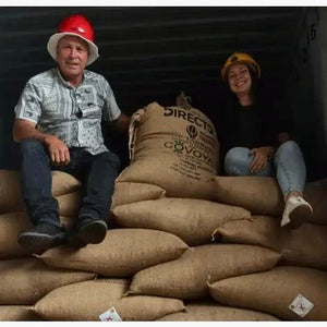 los productores de la finca de casa de piedra, junto con los sacos de cafe