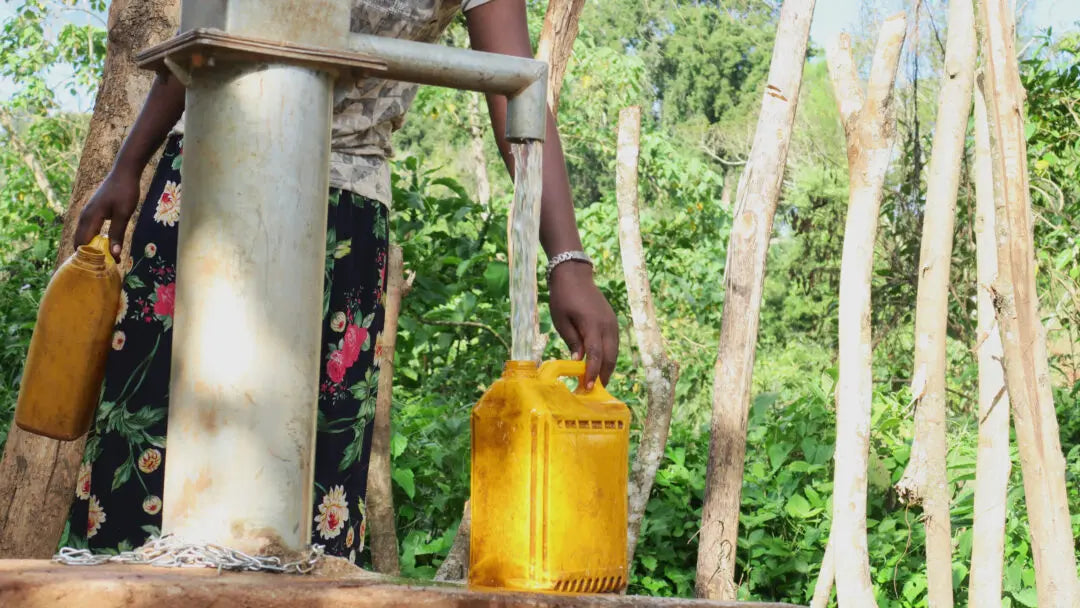 Agricultore etíope llenando garrafa de agua en la finca shakiso en la región de guji 