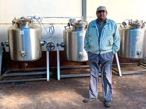 ashok patre enfrente de los tanques de fermentacion